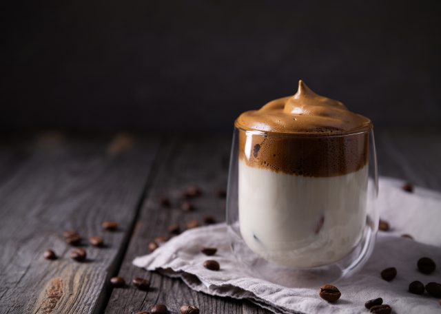 Keto dalgona whipped coffee with milk in a glass