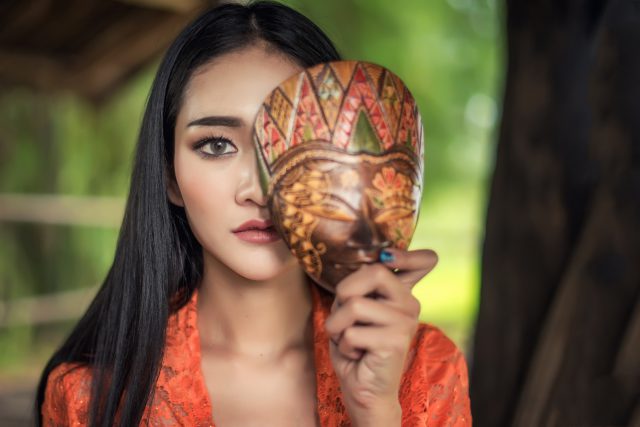 Beautiful Balinese women in traditional costumes, With mask cult