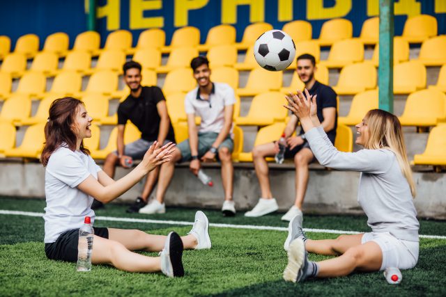 pretty-football-player-man-stretching-leg-muscle-preparing-match-stadium